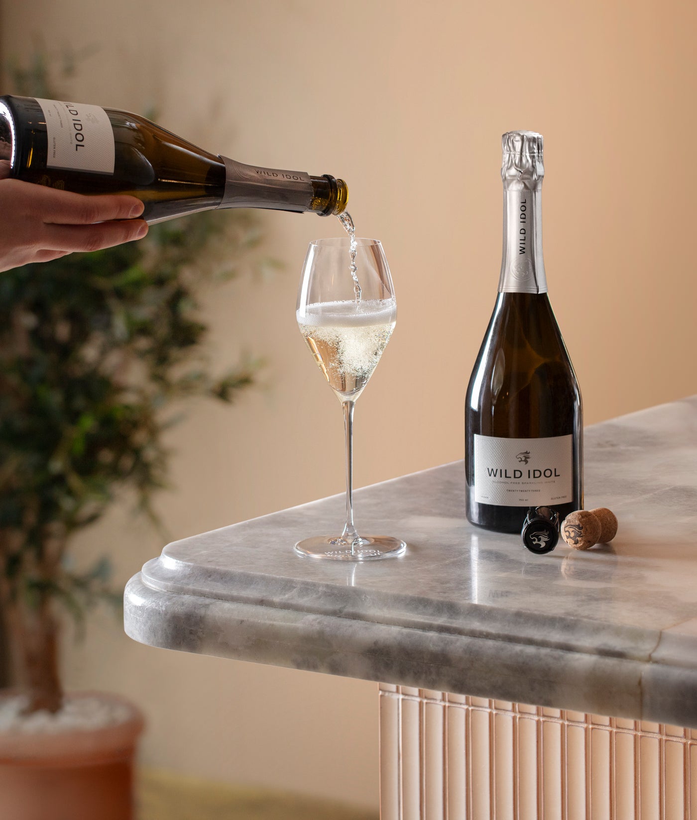 Wild Idol Sparkling White poured at a marble bar